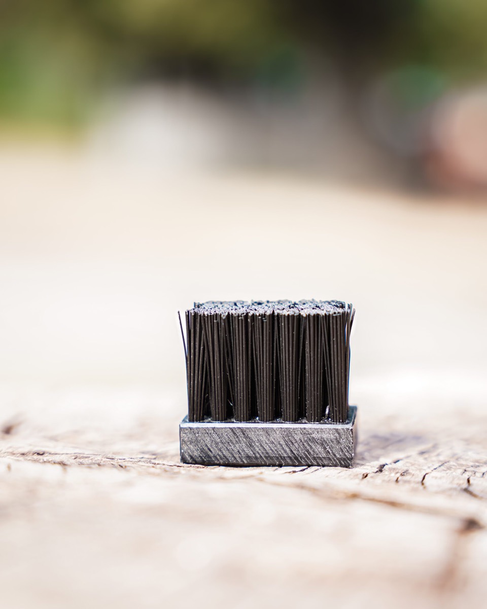Brosse de cure-pied posée sur une bille de bois