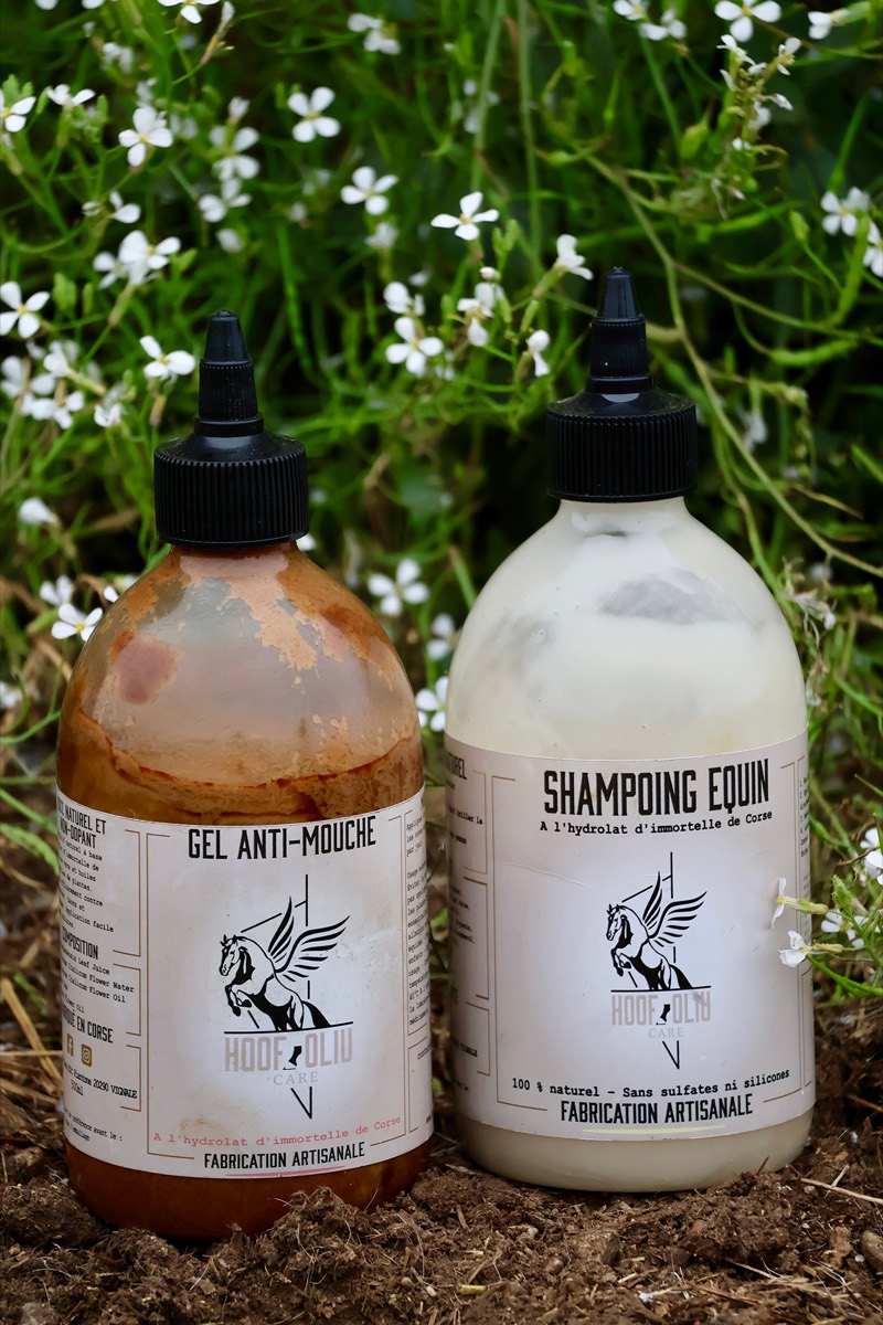 Flacons de gel anti-mouche et de shampoing équin dans l’herbe fleurie